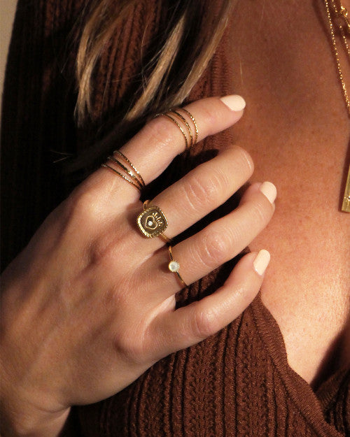 femme portant des bagues Nilai : la mini athéna nacre, la mini oracles et la mini norma