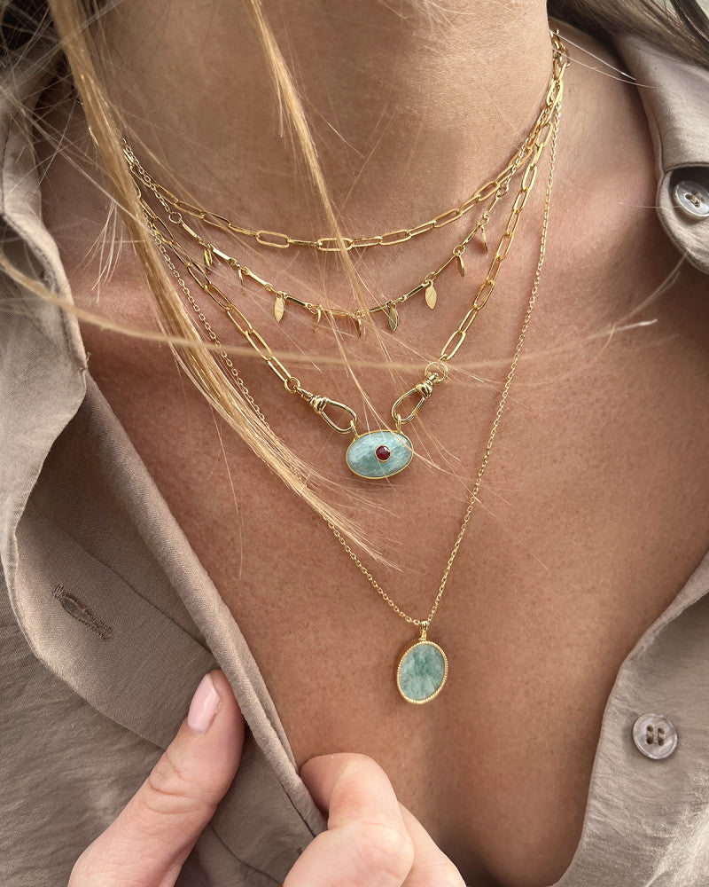 femme portant une chemise beige et des colliers de la marque nilai. Elle porte le collier pure, le collier camille, le collier deva et le collier frida amazonite