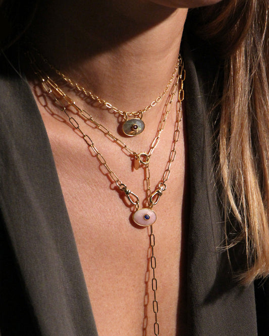 femme portant un blazer noir et des colliers de la marque nilai. Elle porte le mini deva, le deva et le sautoir pure