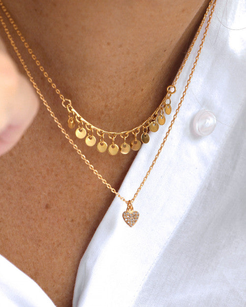 femme portant une chemise blanche et des bijoux de chez nilai dorés