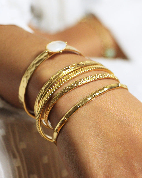 femme portant un ensemble de jonc doré de la marque de bijoux nilai