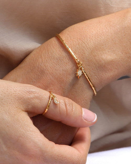 femme portant un jonc avec pendentif étoile polaire et une bague lune en plaqué or