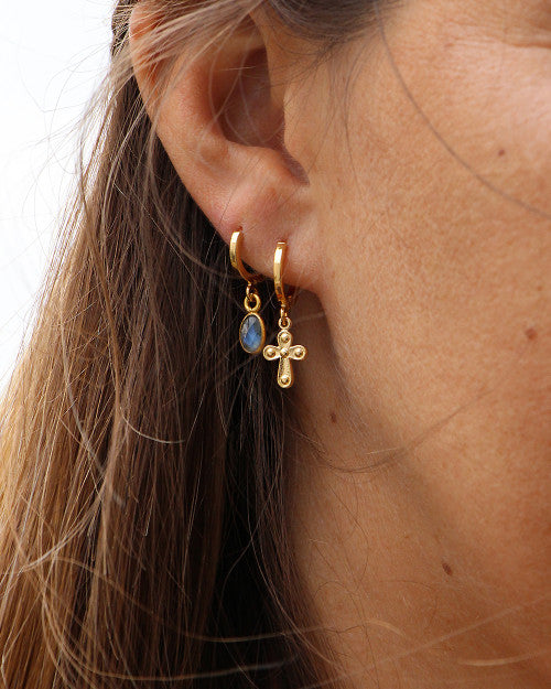 femme portant une mini créole avec croix et boucles d'oreilles avec pierre
