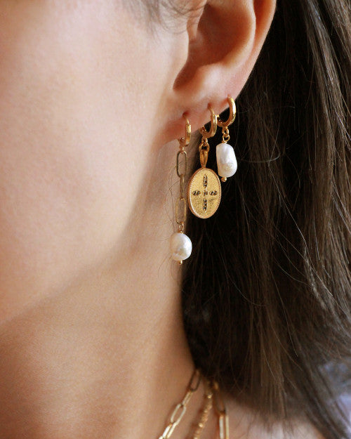 oreilles portant boucles d'oreilles et créoles nilai ornées perles blanches et zircons noirs