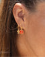 femme portant des boucles d'oreilles croix et bélize orange