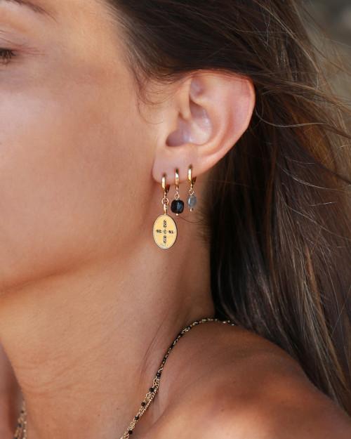 femme portant boucles d'oreilles nilaï ornées pierres noires