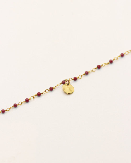 Bracelet Nilaï orné perles bordeaux et petite médaille