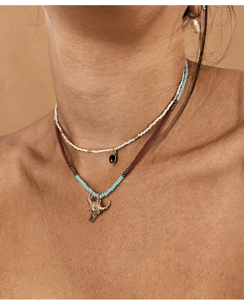 femme portant 2 colliers. Elle porte le collier arizona turquoise tête de taureau de chez nilai ainsi qu'un collier en perles de miyuki 