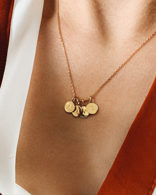 femme portant un collier doré avec les initiales love