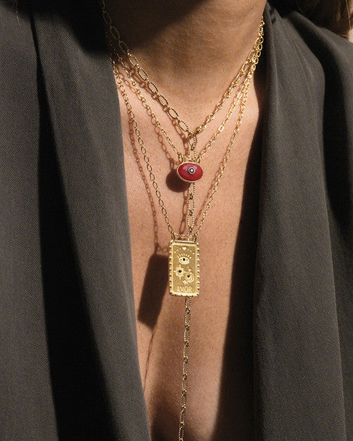 femme portant un blazer noir et des bijoux nilai : le collier buena ventura, le collier mini deva agate rouge et le sautoir pure torsadée