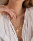 femme portant collier paloma et chemise blanche