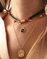 femme portant le collier surfer nilai composé de pierres howlites noires. Elle porte aussi le collier sally et le collier bélize noir