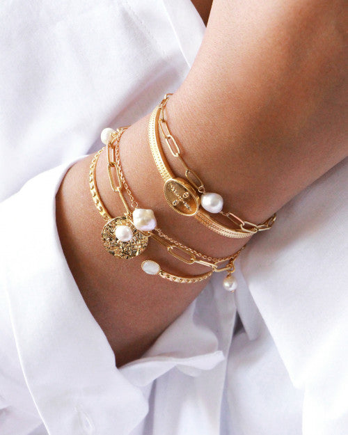 poignet portant bracelets avec perles d'eau douce et dorés