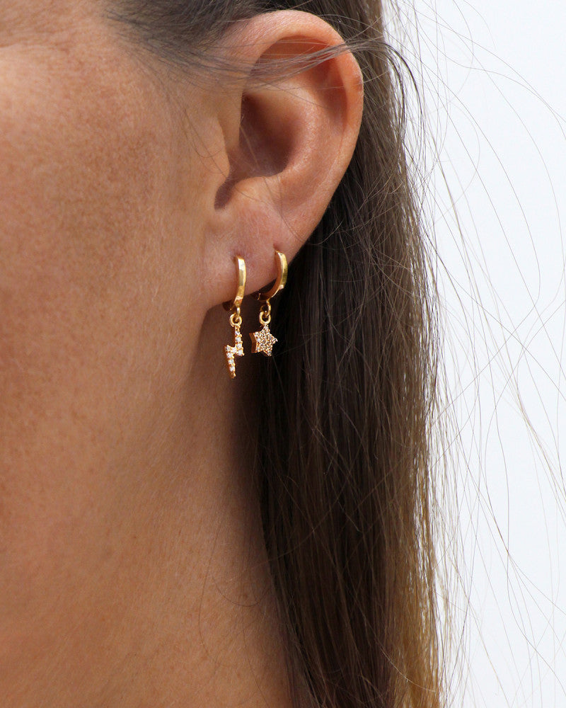 femme portant deux boucles d'oreilles dorées de chez nilai à la même oreille