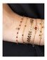 poignet portant bijoux or et rouge nilai